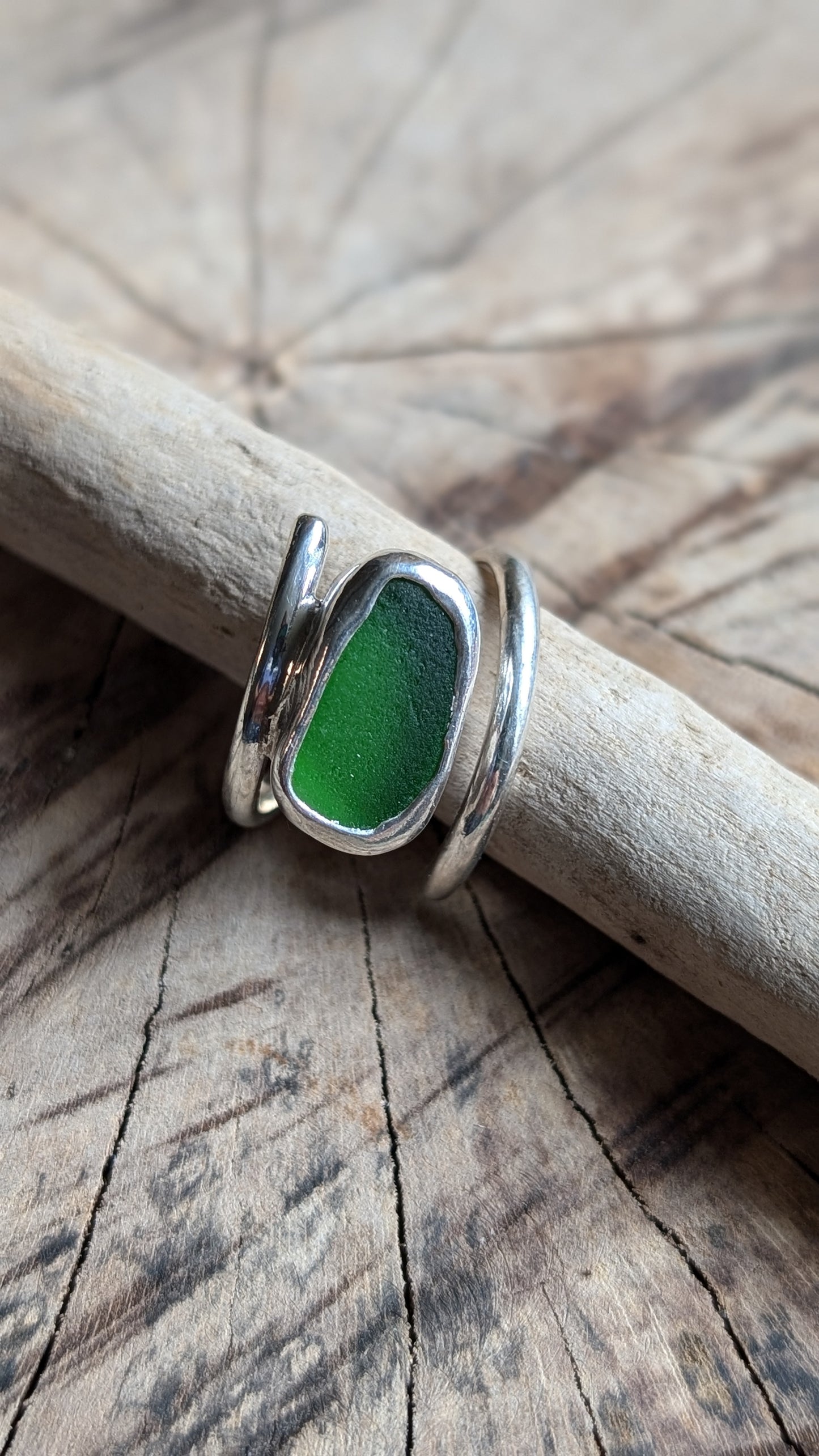Adjustable green sea glass ring encased in silver bezel