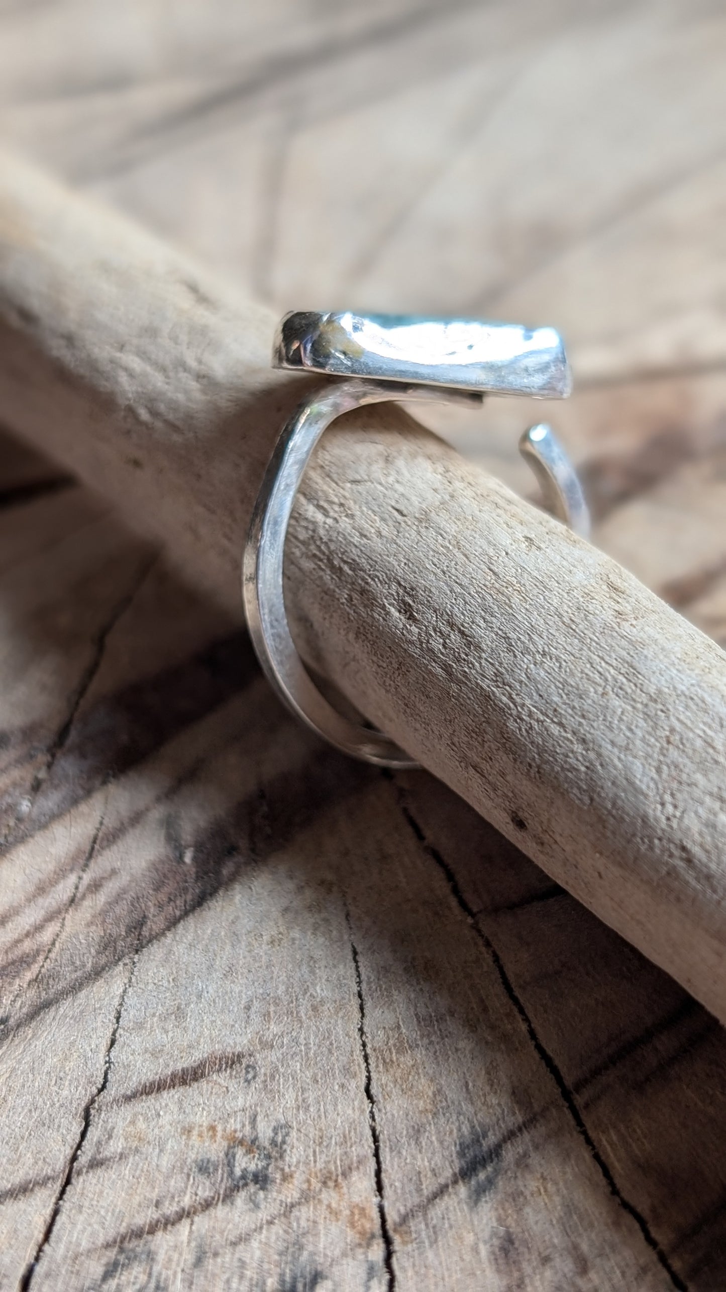 Adjustable blue sea glass ring encased in silver bezel