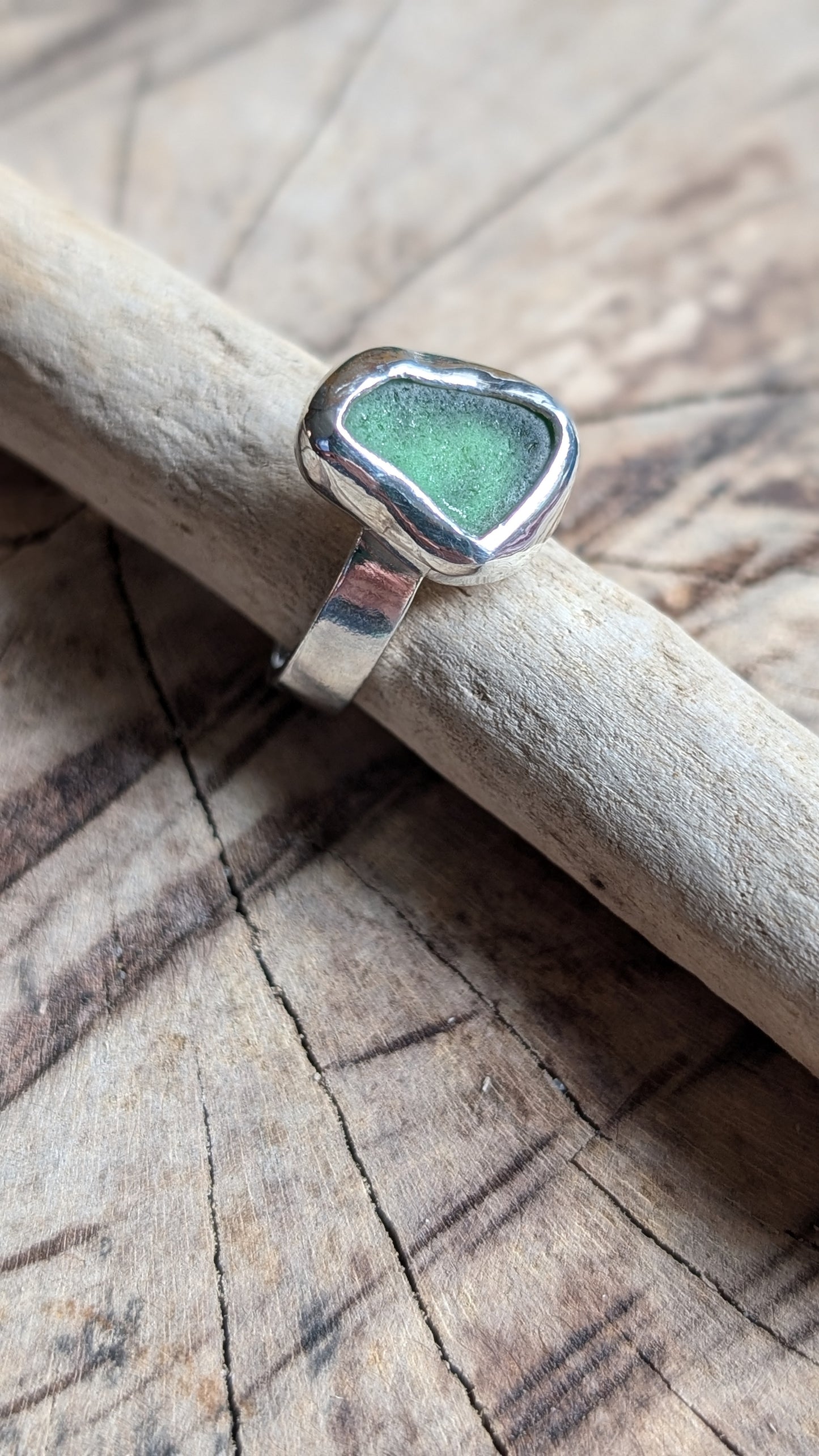 Green sea glass ring encased in silver bezel