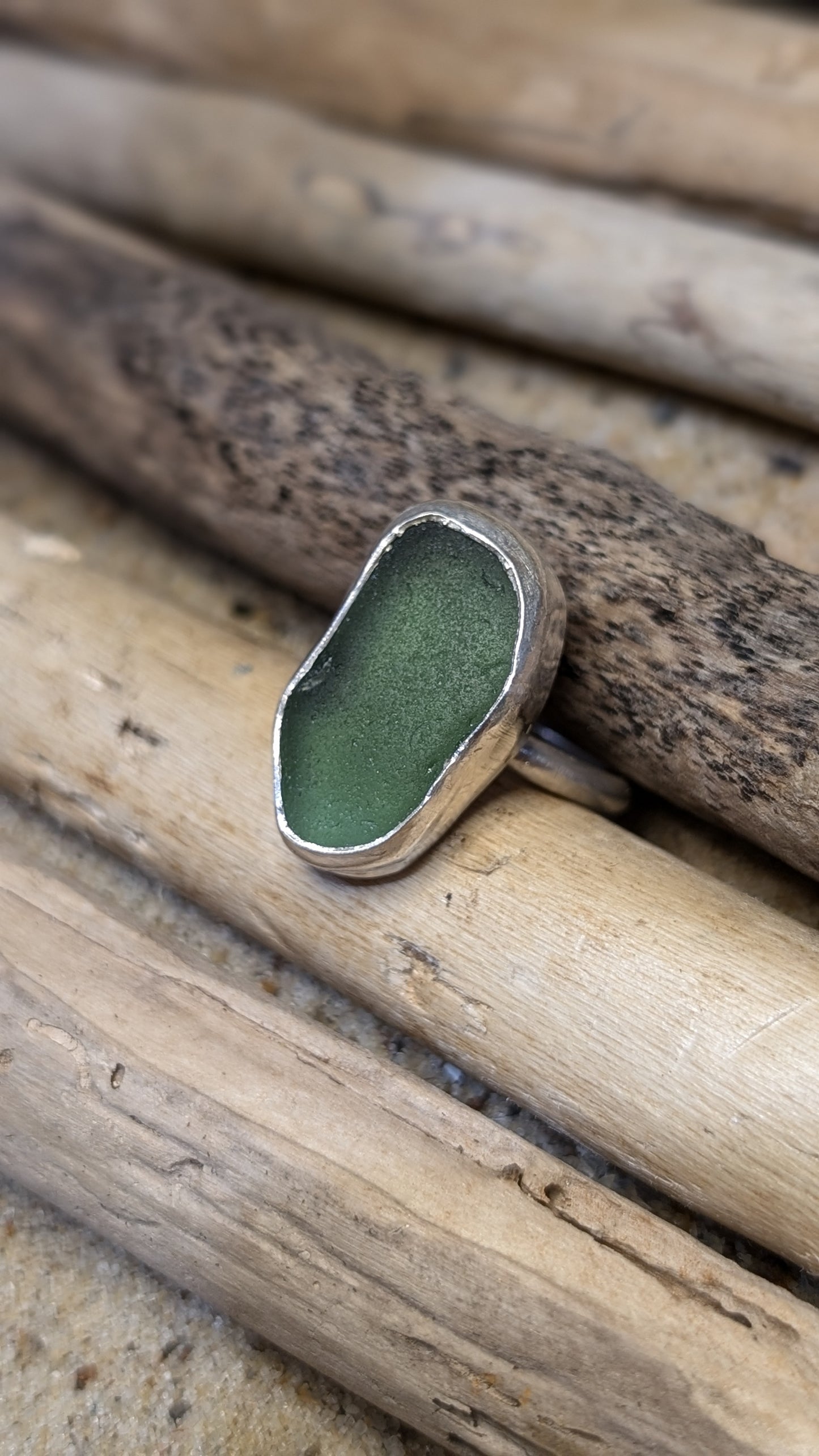 Green sea glass ring encased in silver bezel