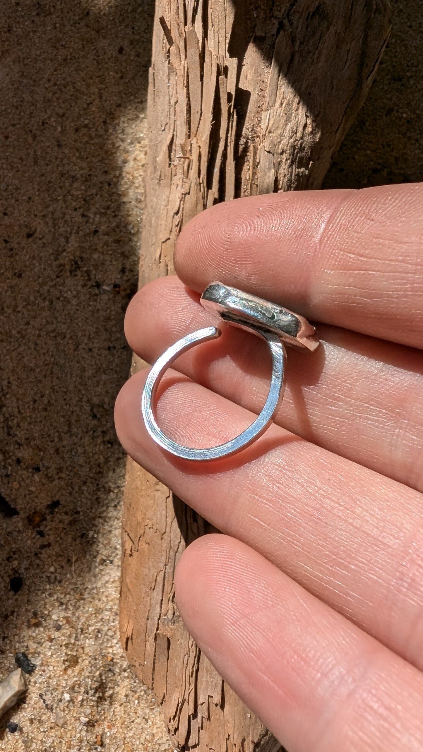 Adjustable blue sea glass ring encased in silver bezel