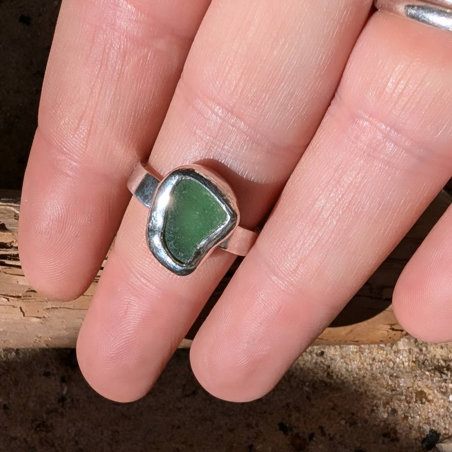 Green sea glass ring encased in silver bezel