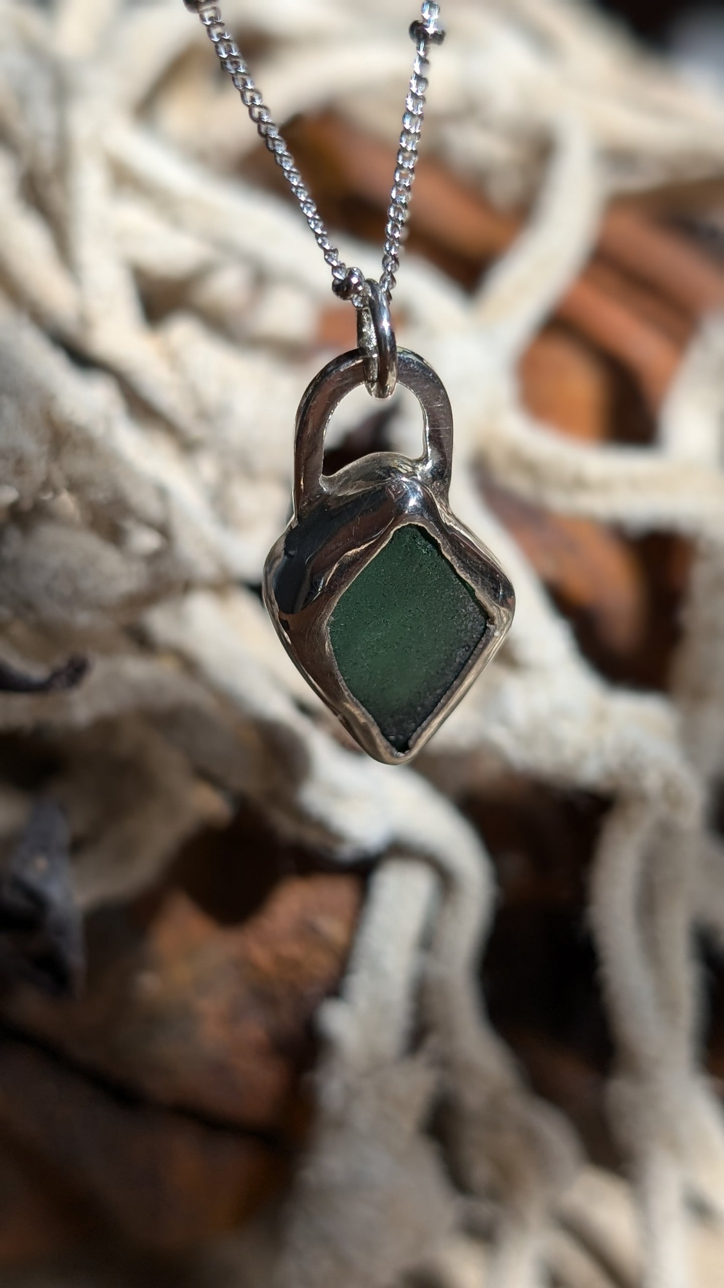 Green/blue sea glass pendant encased in open backed bezel with chain