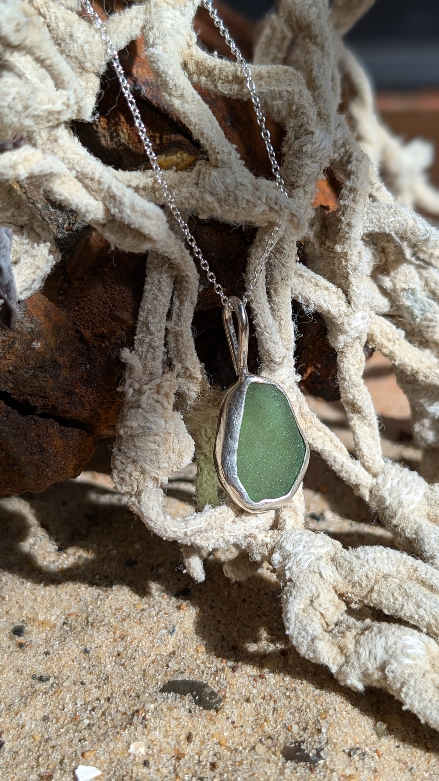 Green sea glass pendant encased in open backed bezel with chain