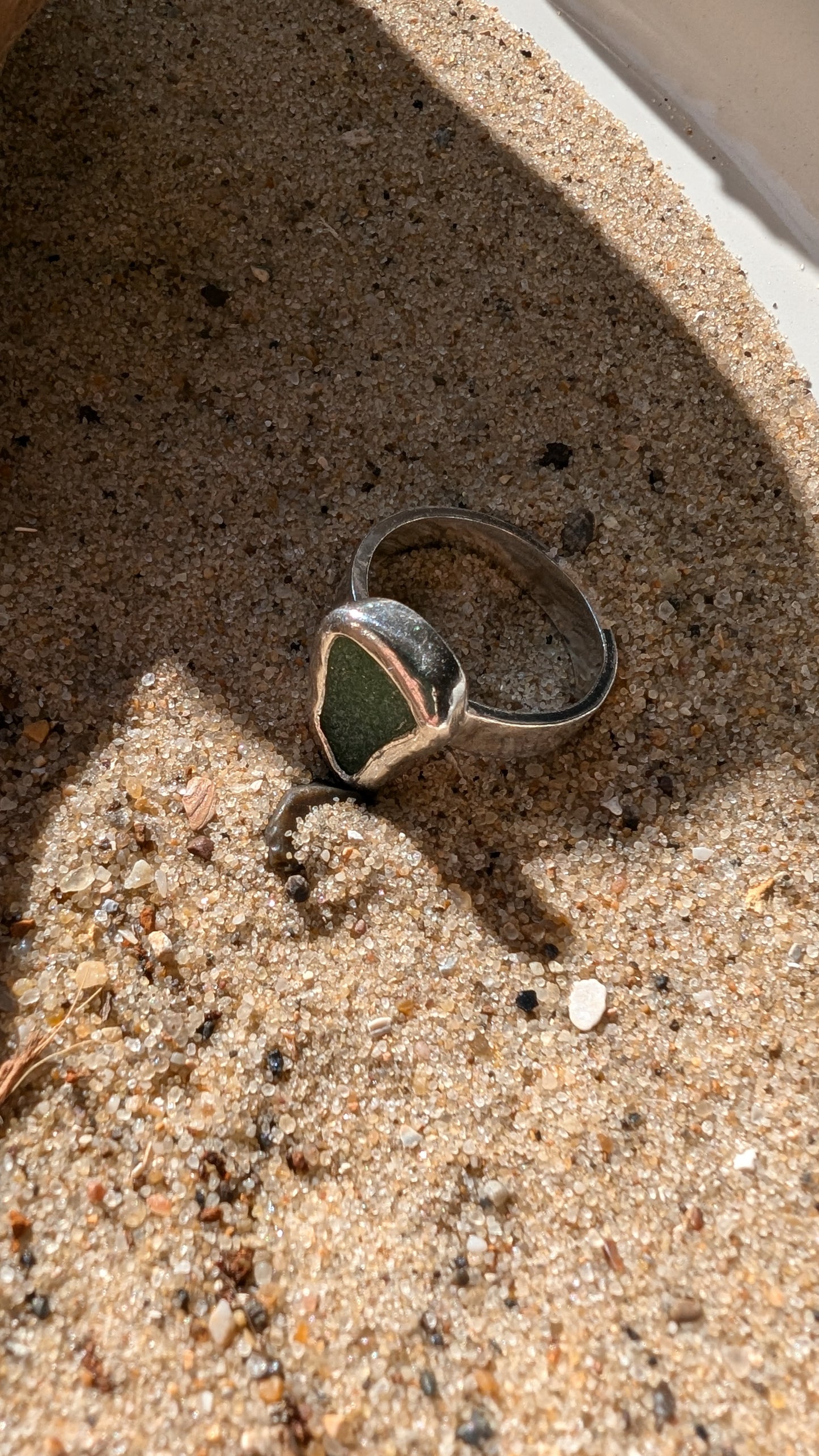 Green sea glass ring encased in silver bezel