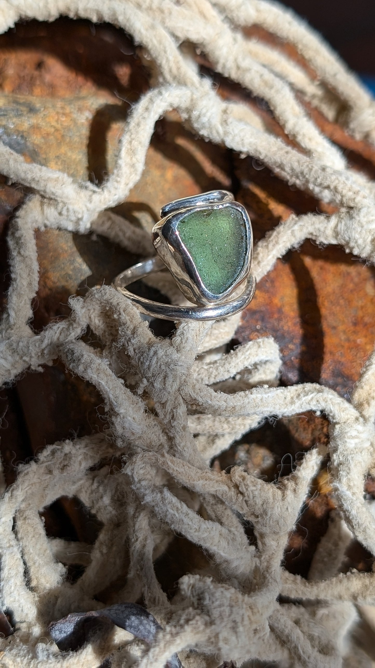 Adjustable green sea glass ring encased in silver bezel