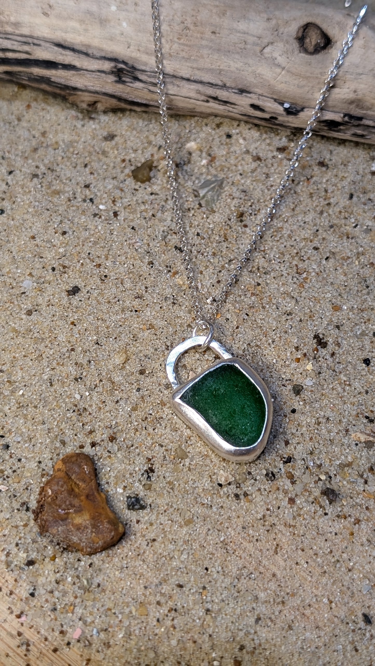 Green sea glass pendant encased in open backed bezel with chain