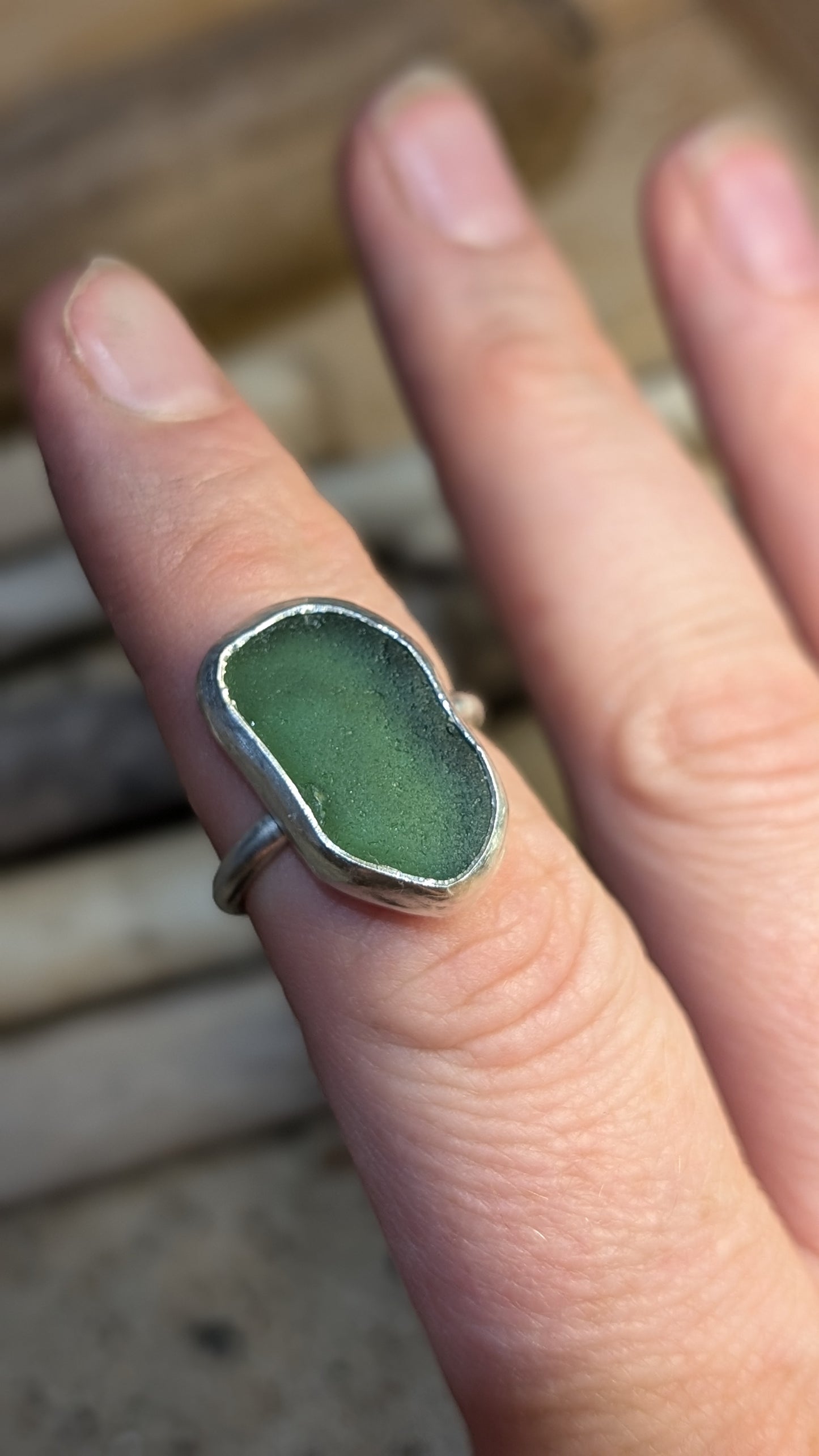 Green sea glass ring encased in silver bezel