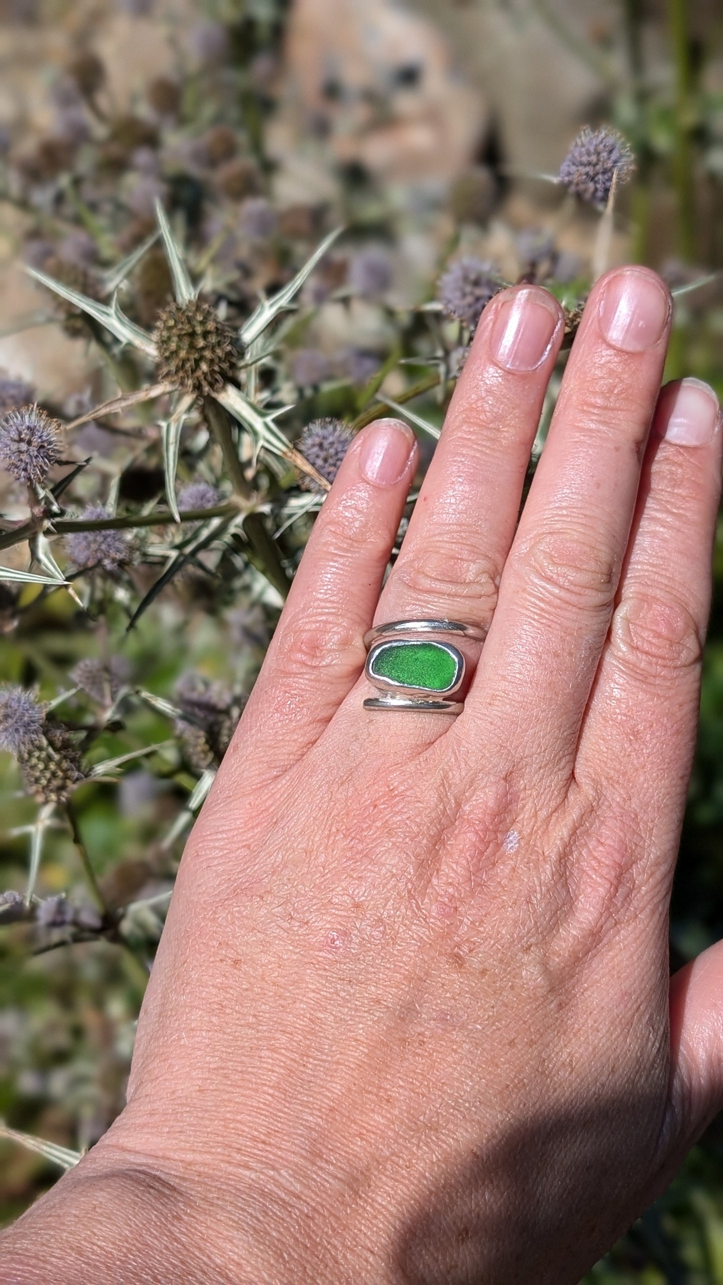 Adjustable green sea glass ring encased in silver bezel