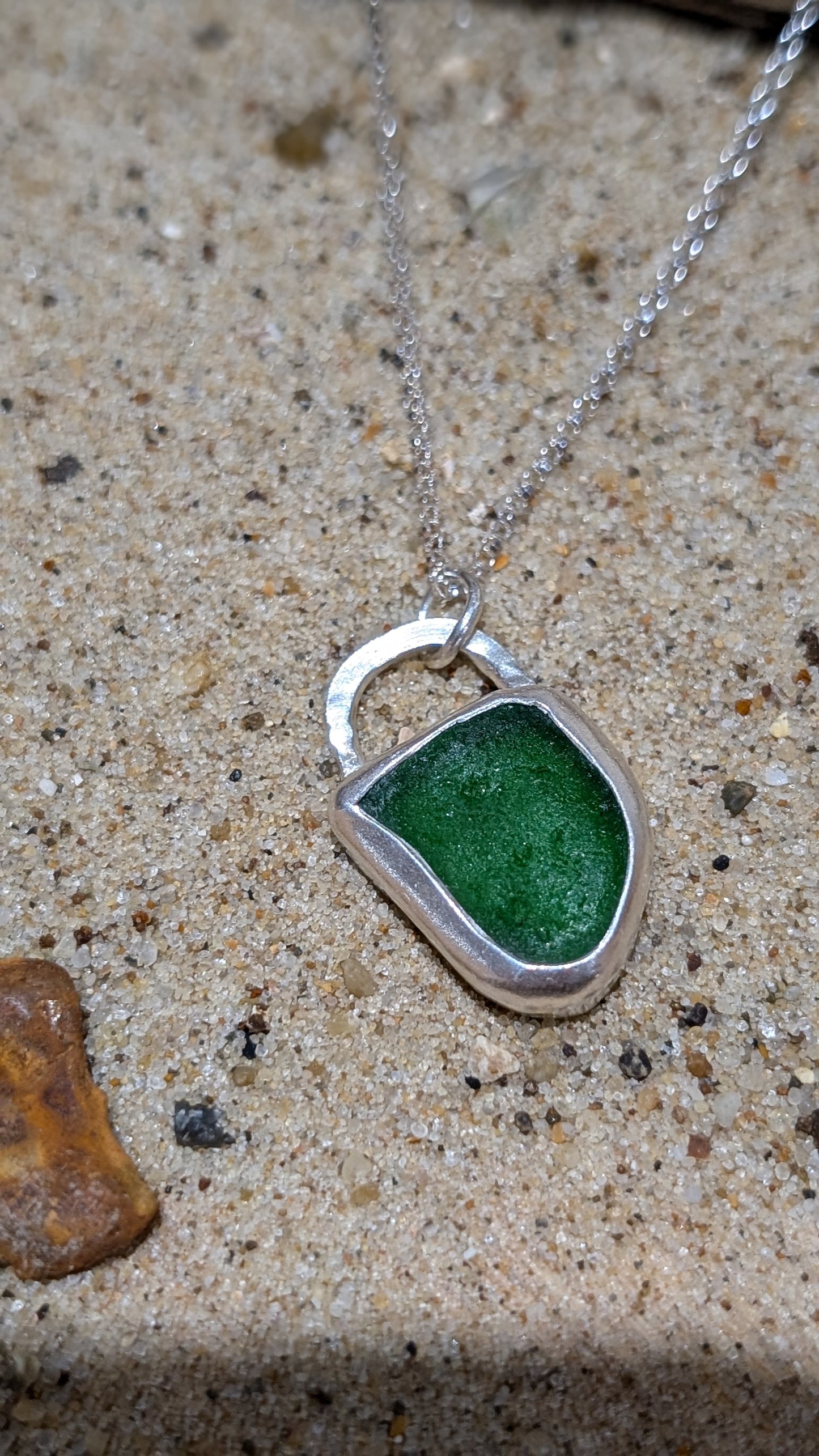 Green sea glass pendant encased in open backed bezel with chain