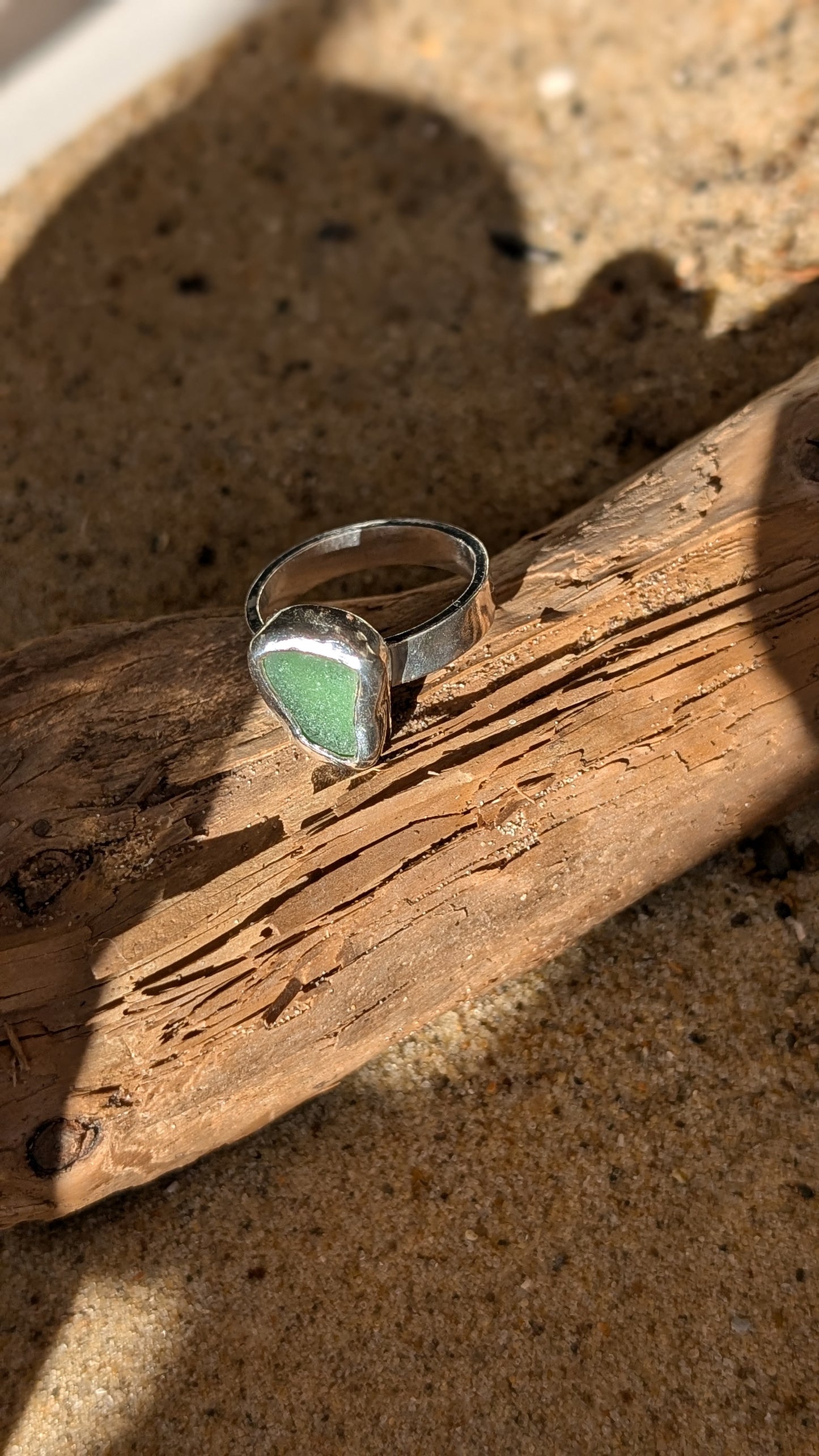 Green sea glass ring encased in silver bezel