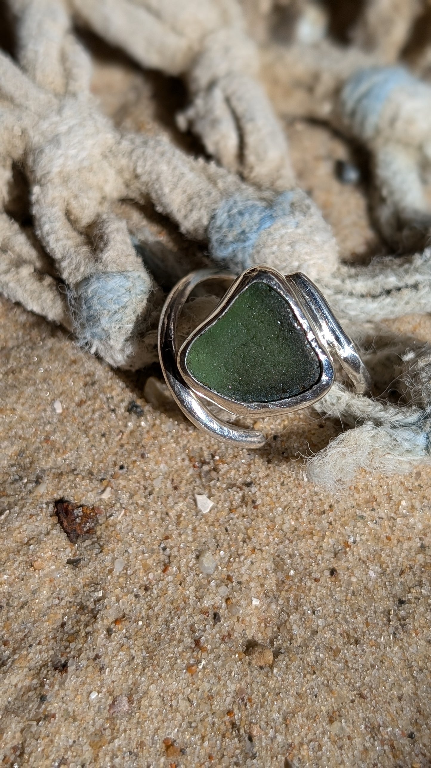 Adjustable green sea glass ring encased in silver bezel