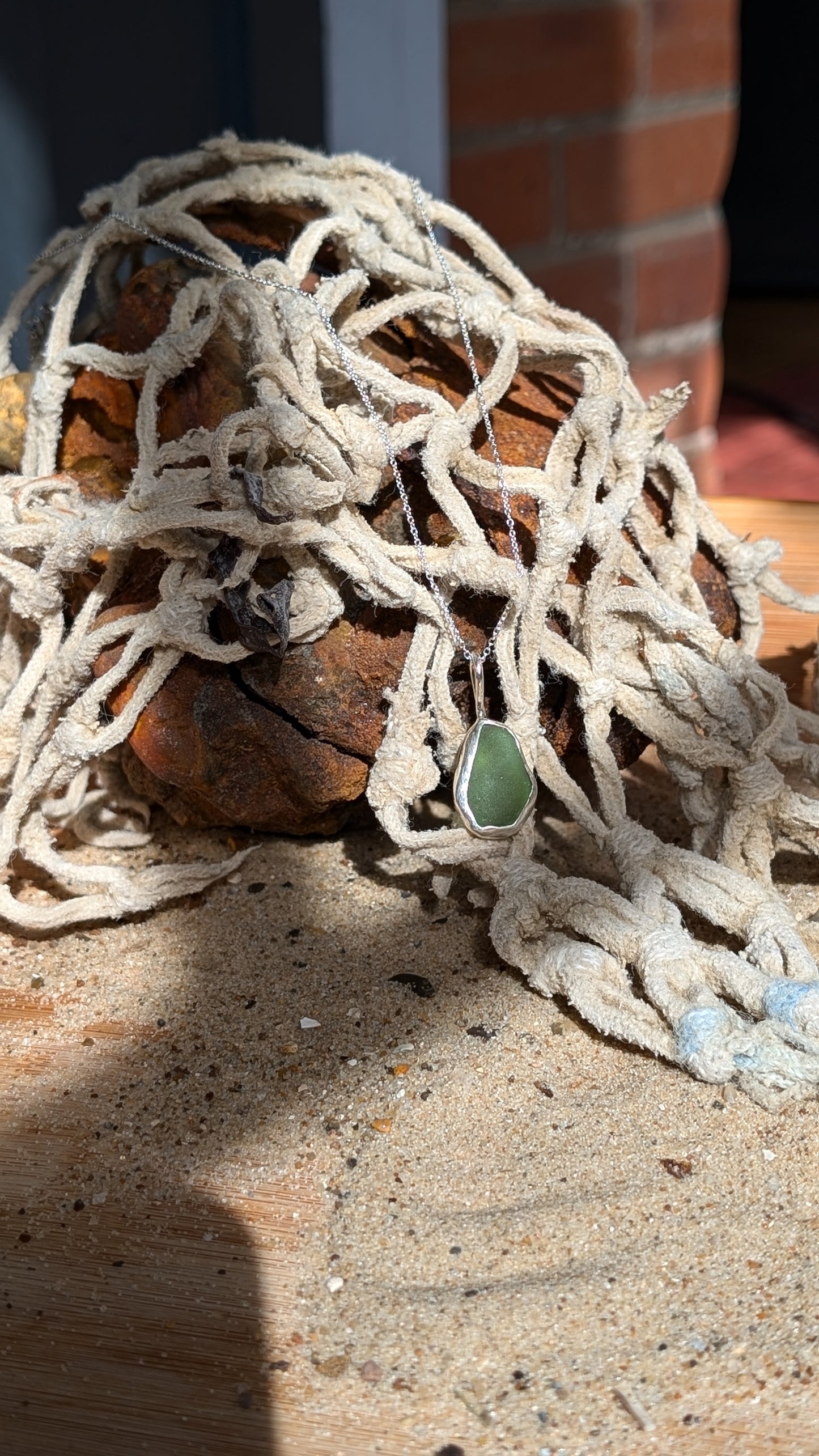 Green sea glass pendant encased in open backed bezel with chain