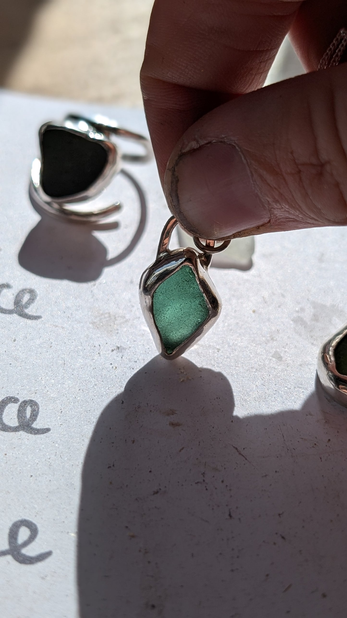 Green/blue sea glass pendant encased in open backed bezel with chain