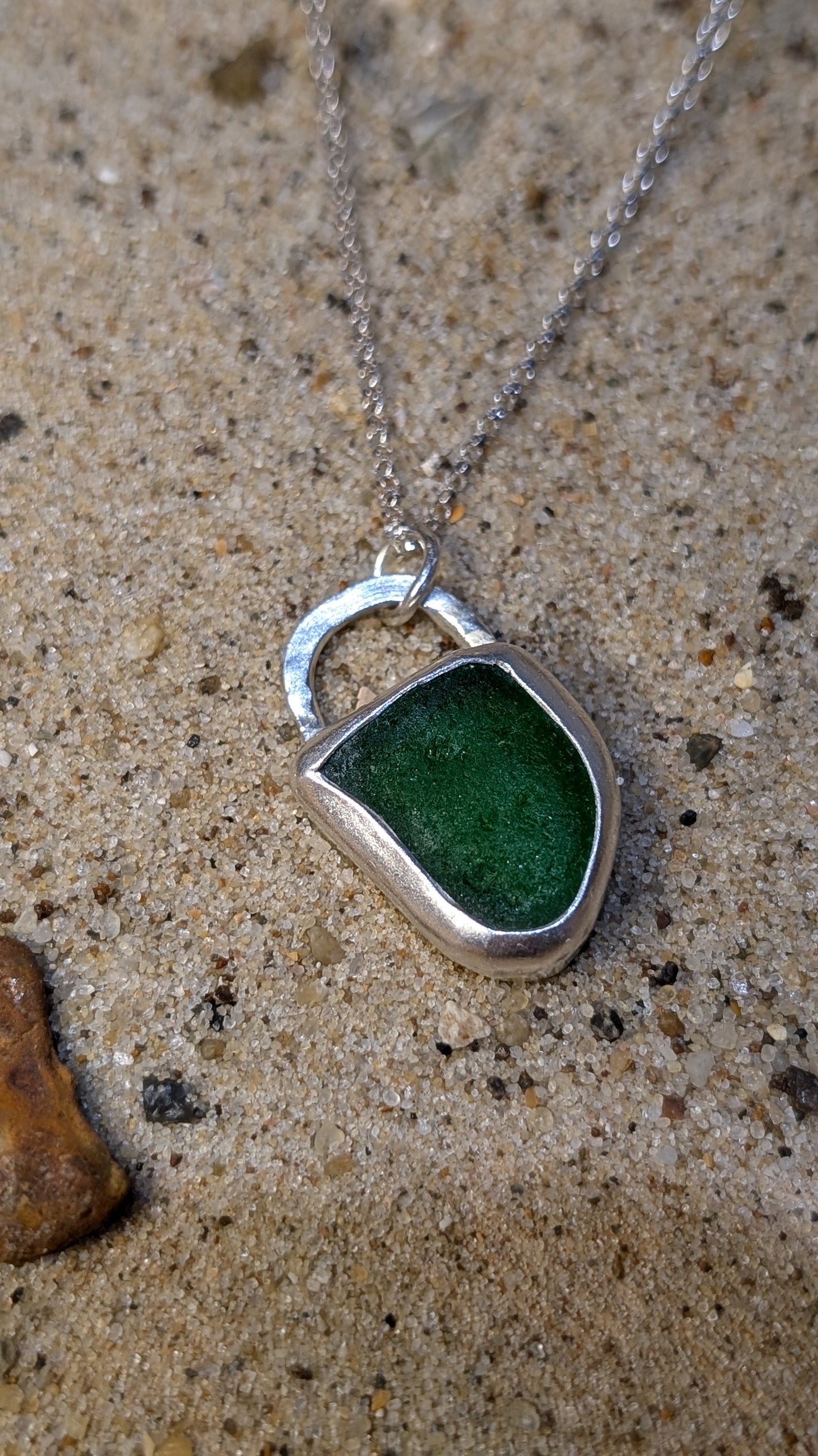 Green sea glass pendant encased in open backed bezel with chain