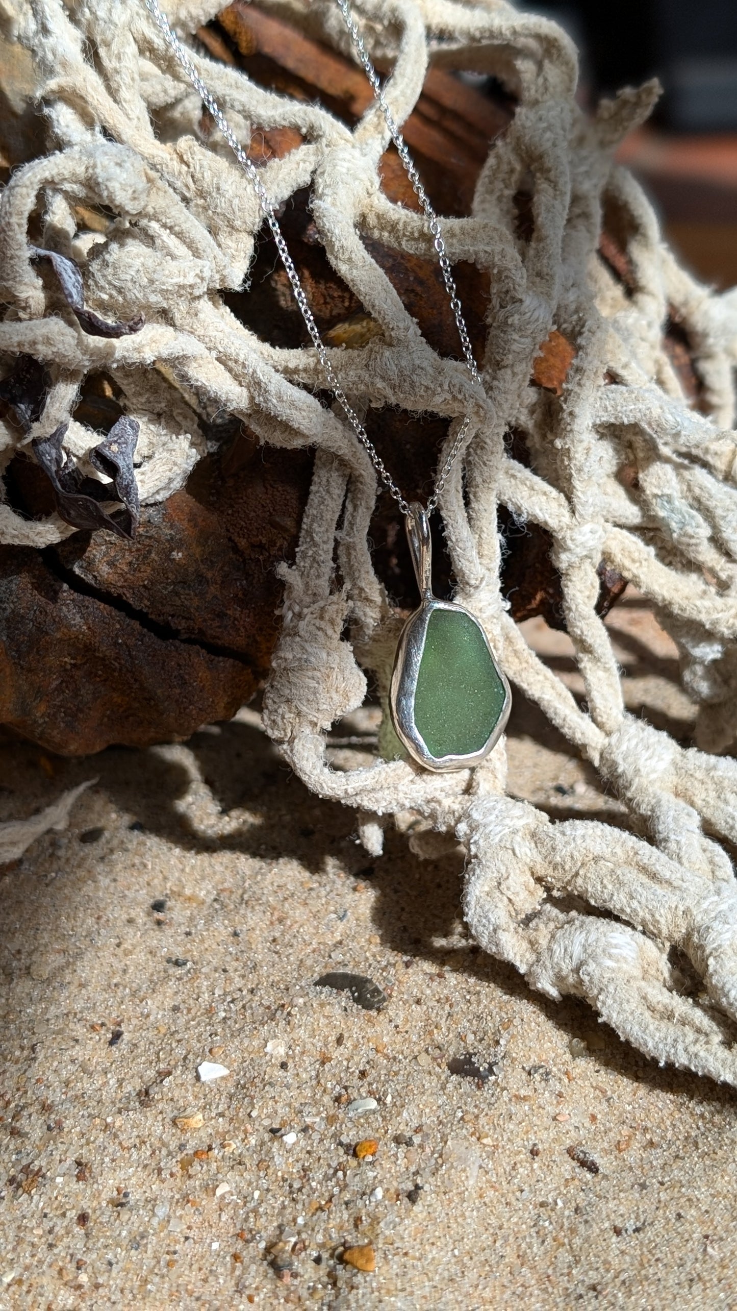 Green sea glass pendant encased in open backed bezel with chain