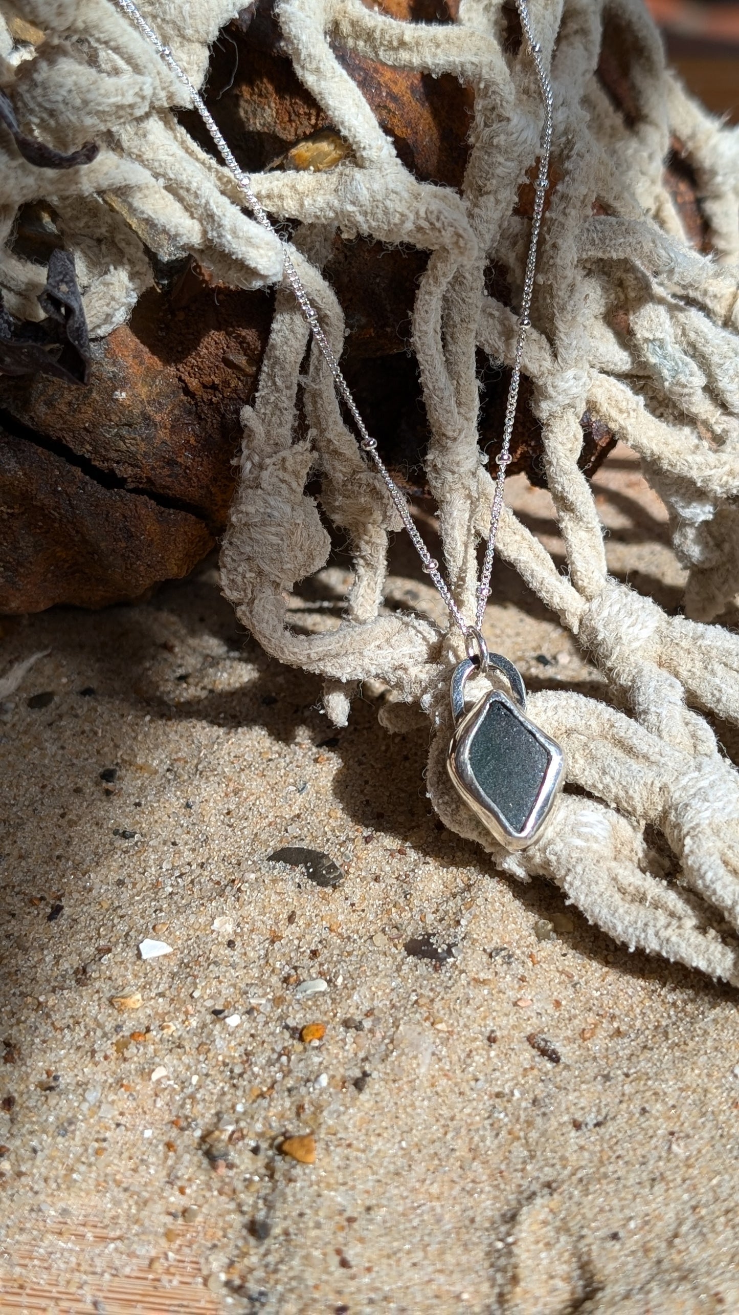 Green/blue sea glass pendant encased in open backed bezel with chain
