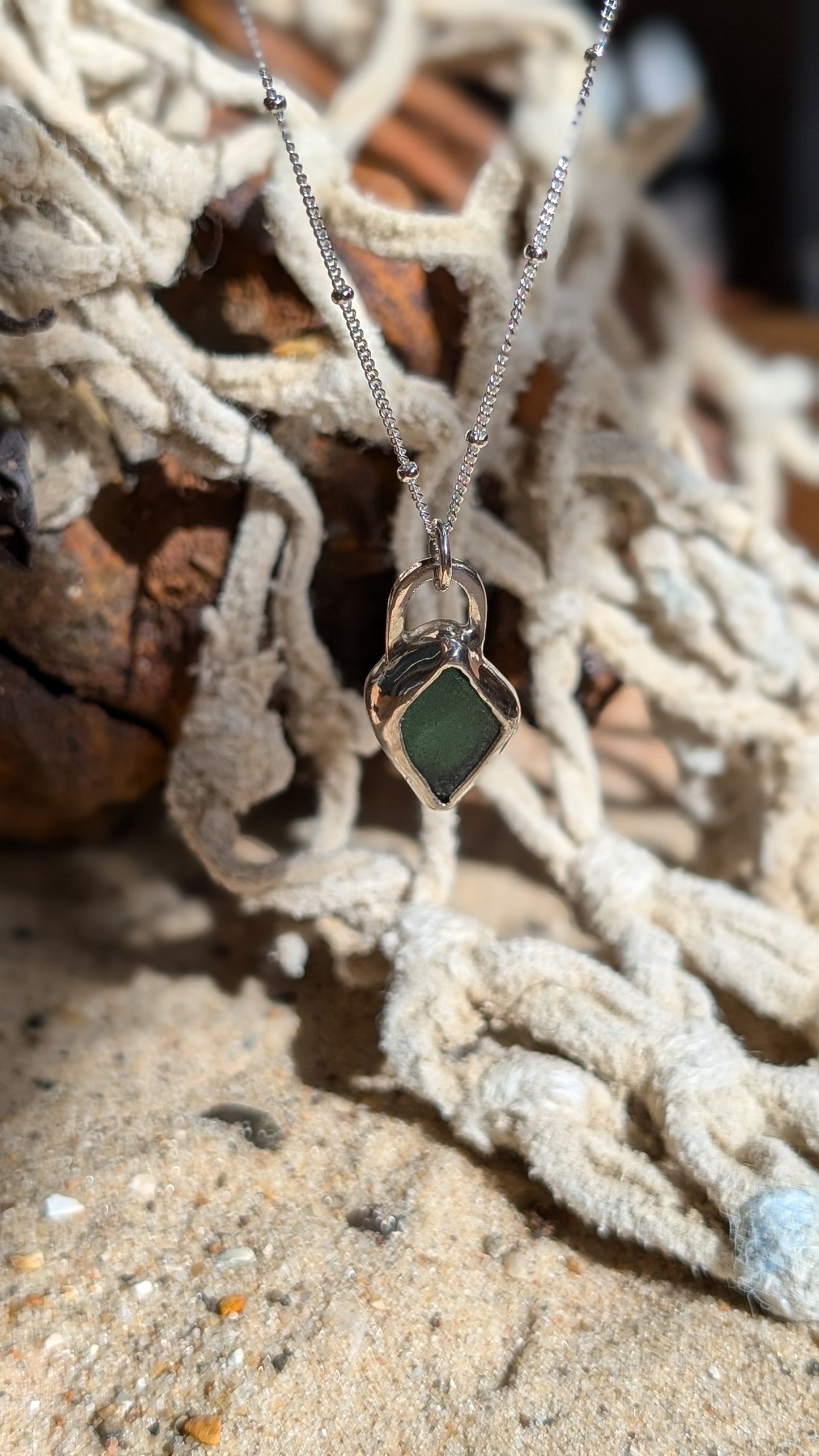 Green/blue sea glass pendant encased in open backed bezel with chain