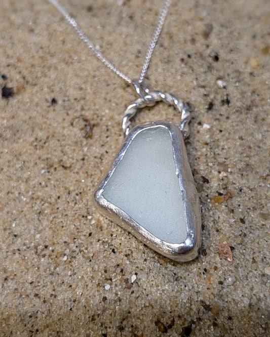 White twisted sea glass pendant encased in open backed bezel with chain